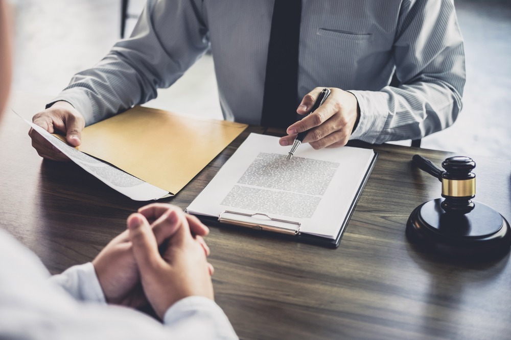 Lawyer reviewing legal documents with a client at a desk.